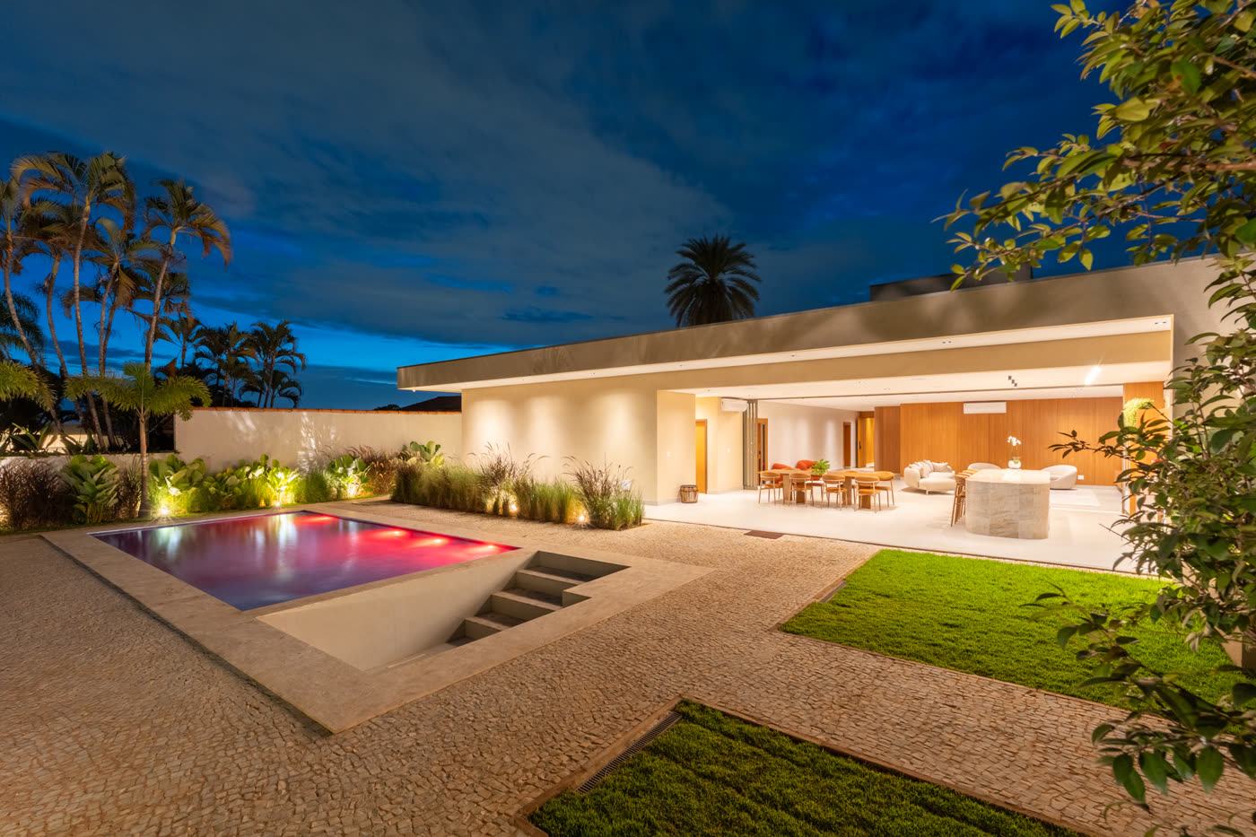 Área de piscina fotografada profissionalmente pela Core Mídias, com iluminação noturna